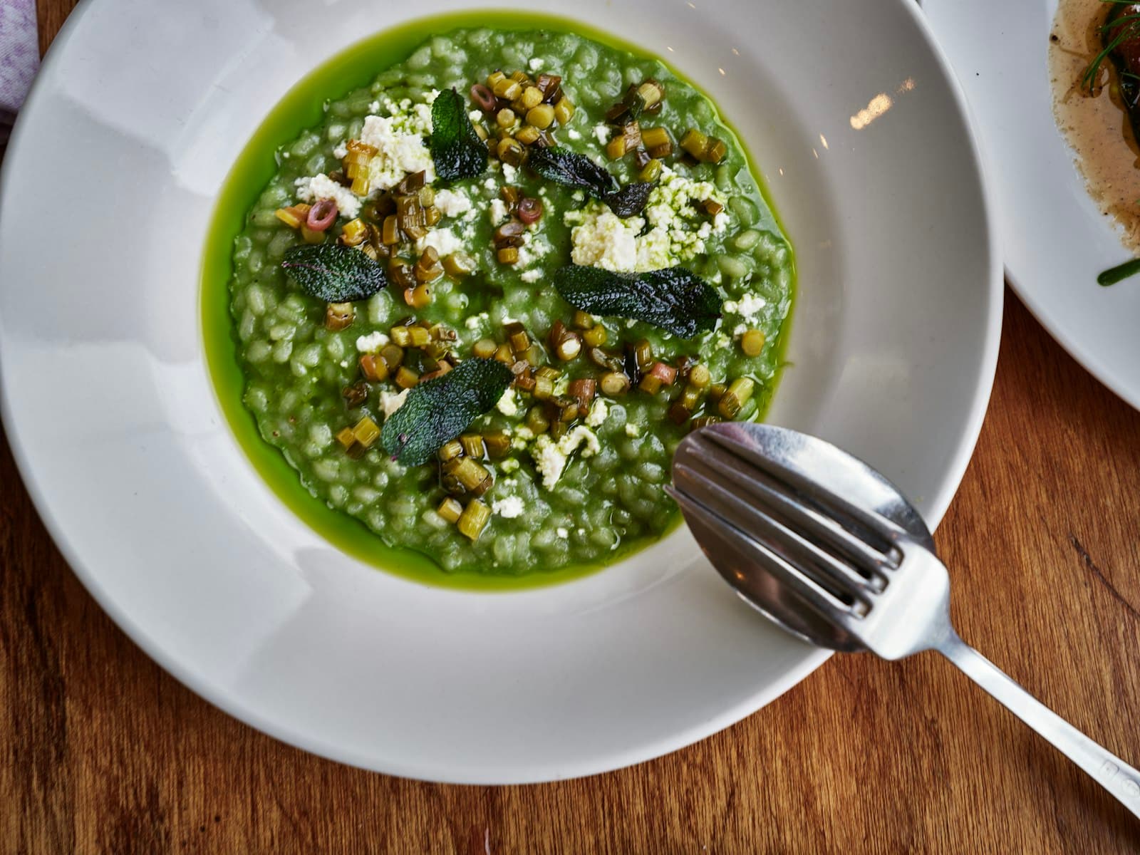 Risotto agli asparagi visto dall'alto, con ricotta di bufala e foglie di salvia croccante