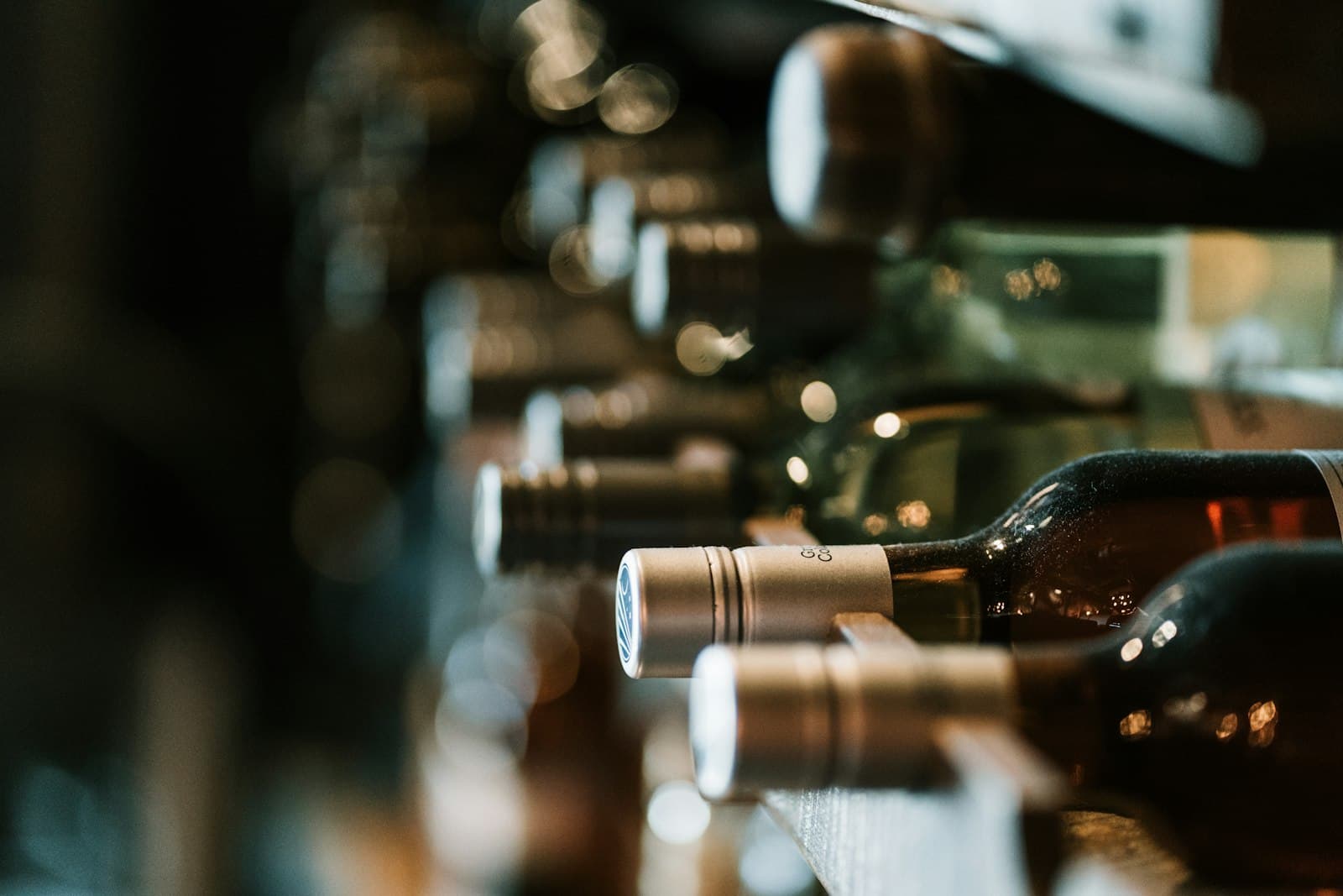 Primo piano di bottiglie di vino allineate in cantina