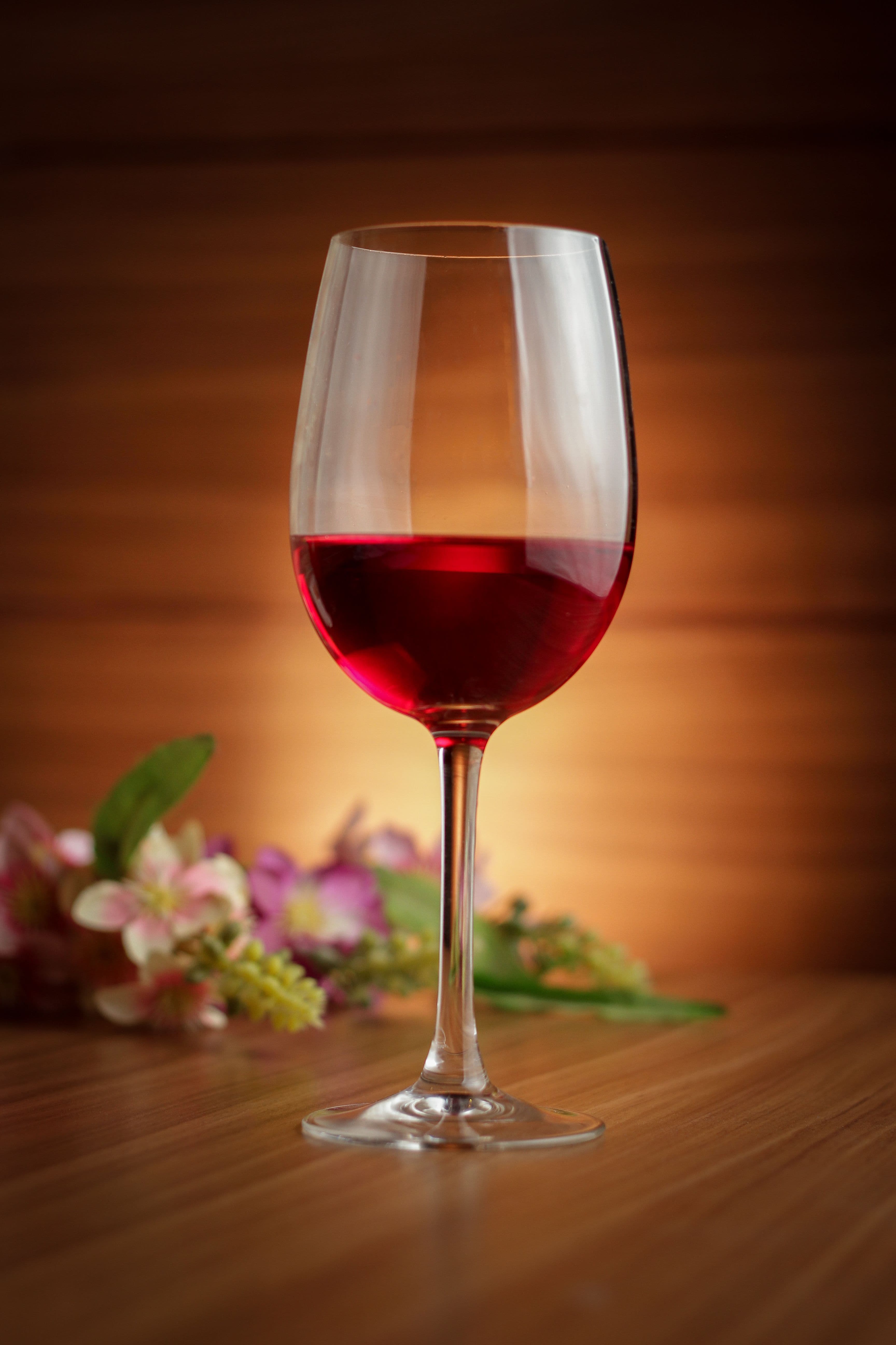 Un calice di vino rosso su un tavolo di legno caldo