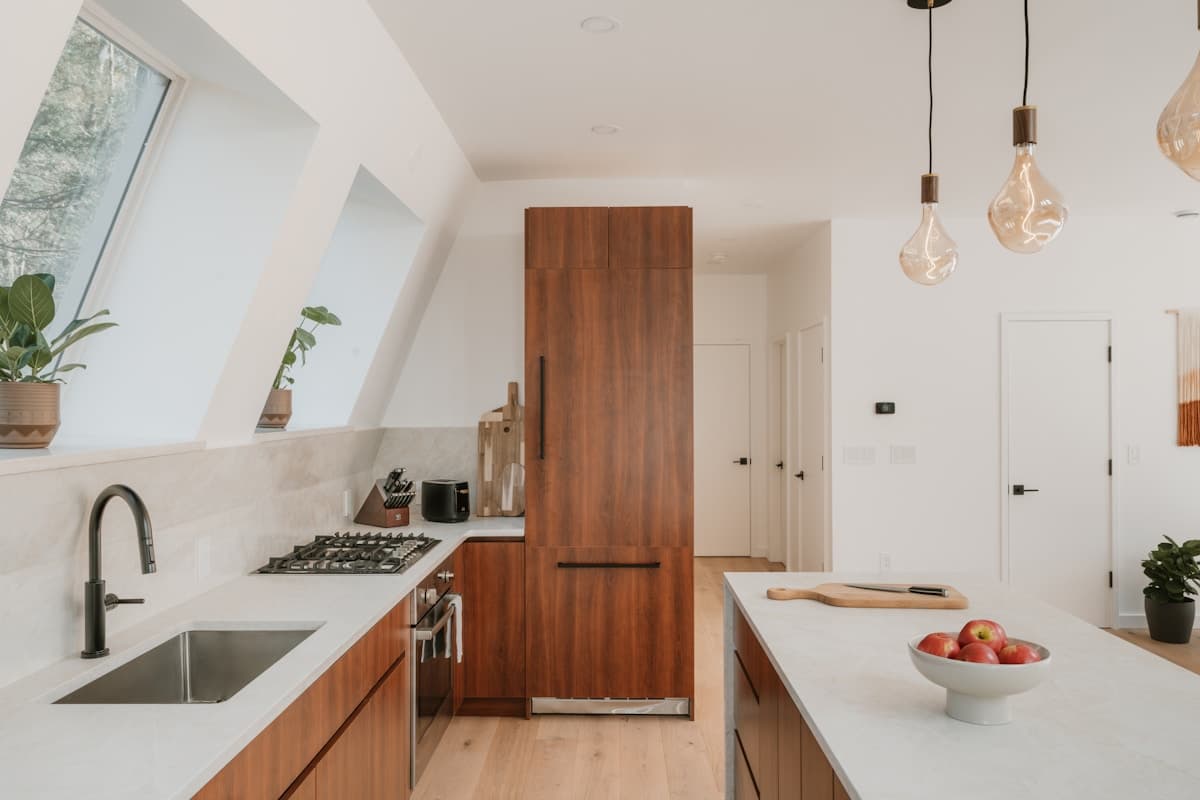 Cucina in legno naturale con finestre ad angolo e lampade a sospensione